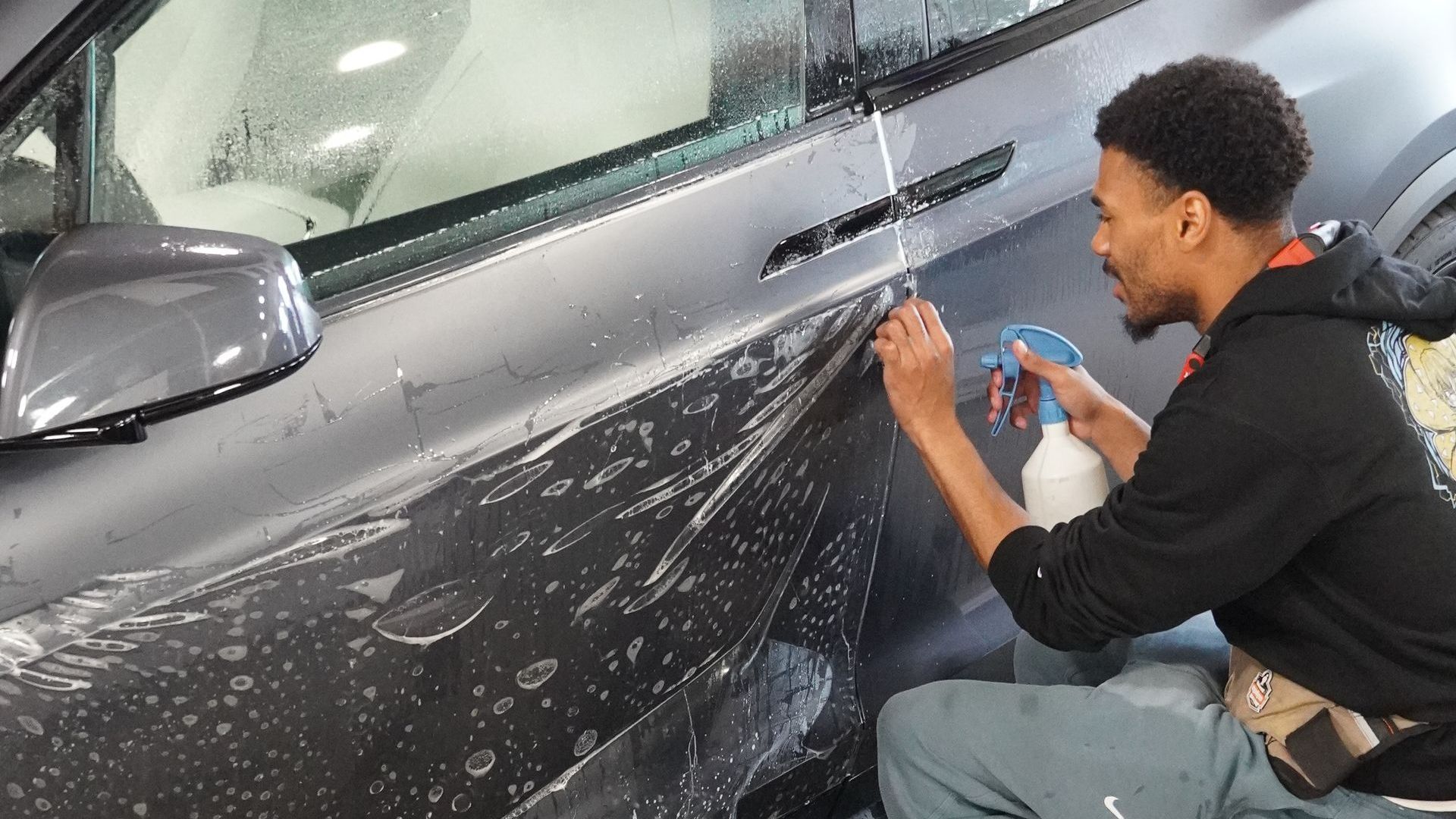 A man is wrapping a car with paint protection film.