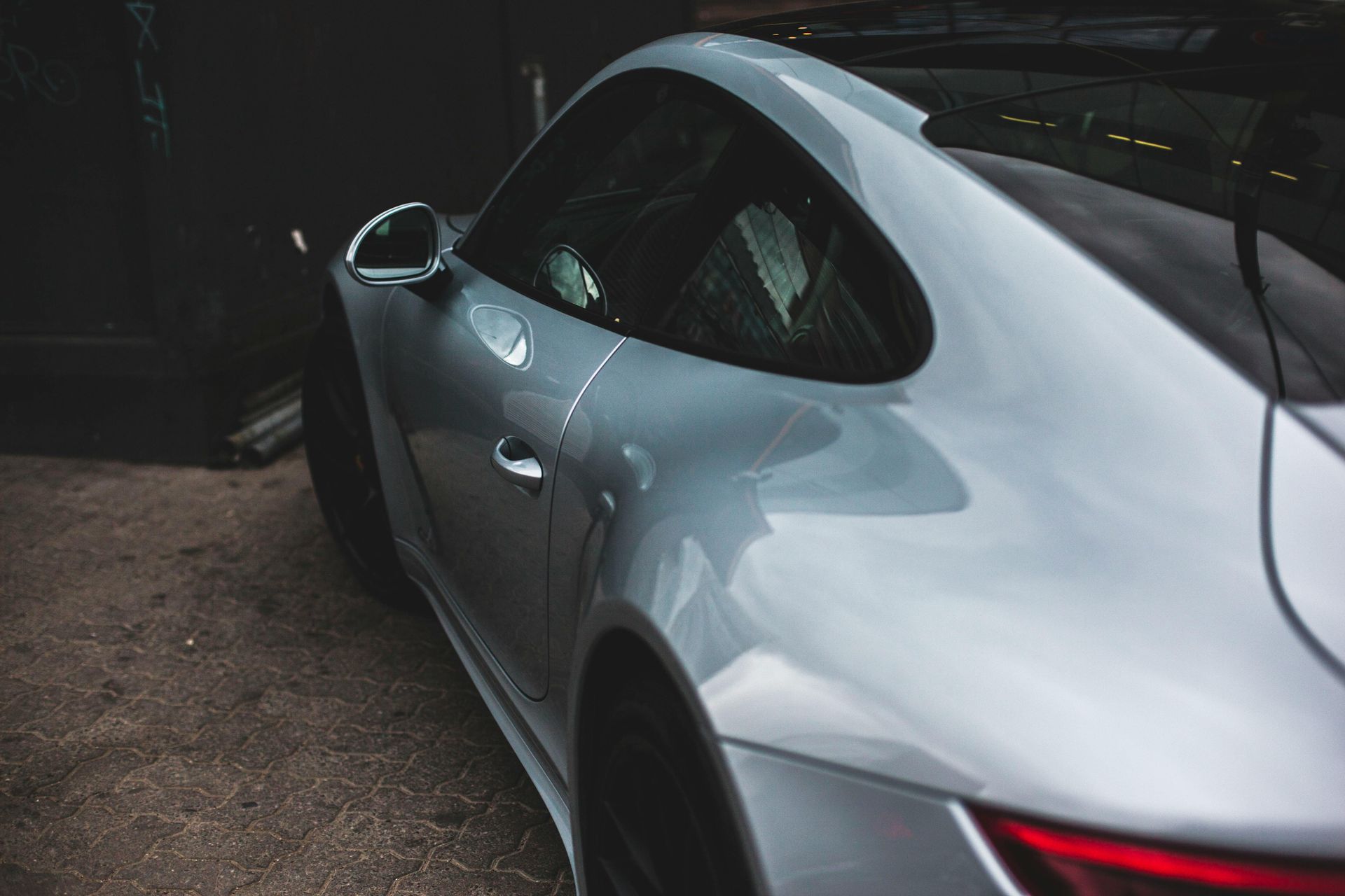 A silver sports car is parked in a parking lot.