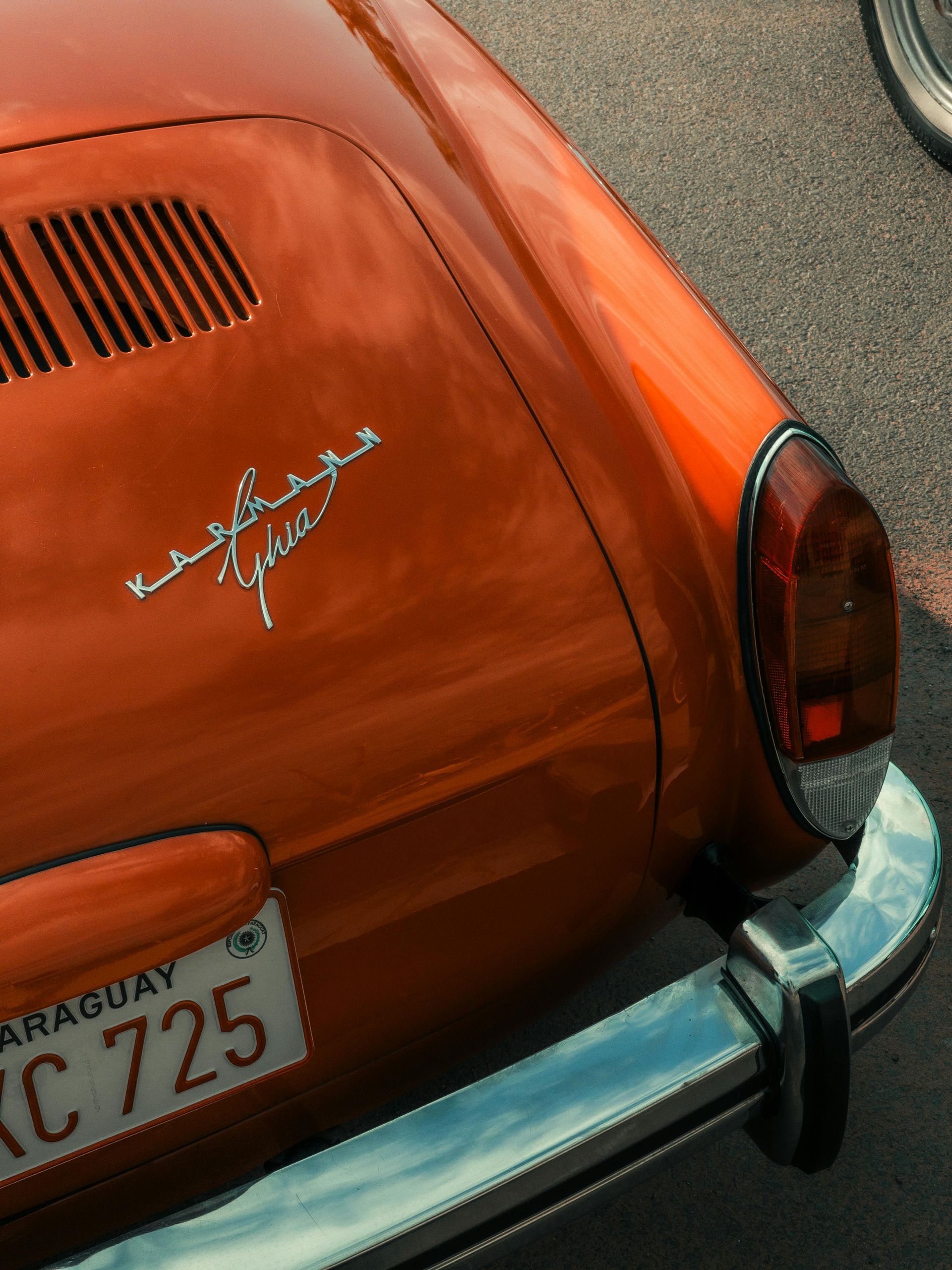 An orange car with a license plate that says kc 725