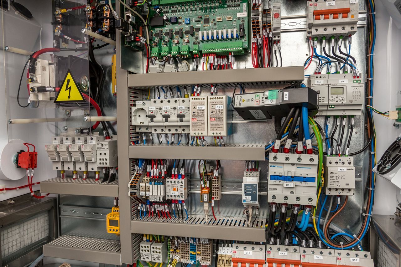 A close up of a electrical control panel with a lot of wires.