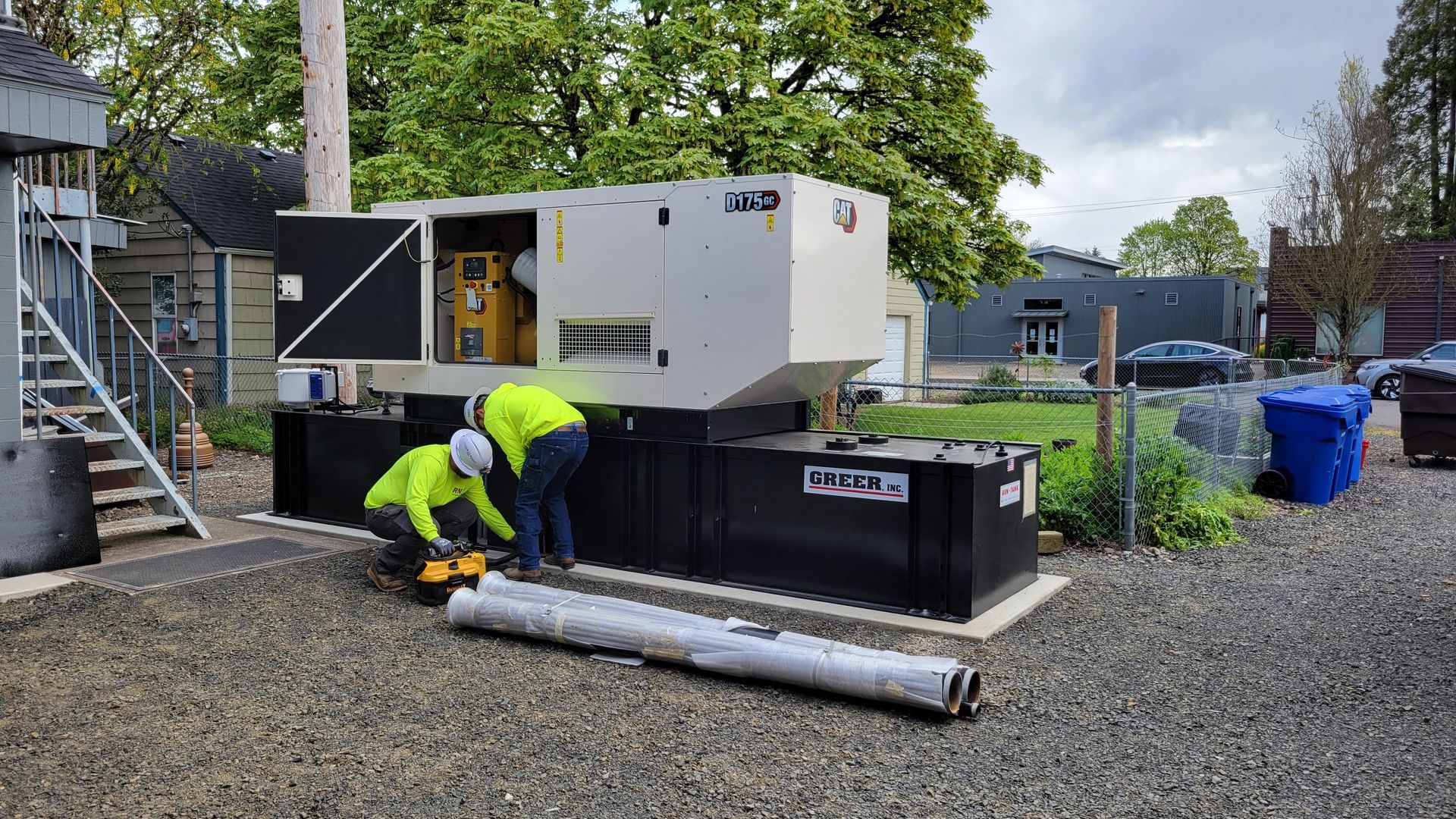 A large yellow generator is parked in front of a building.