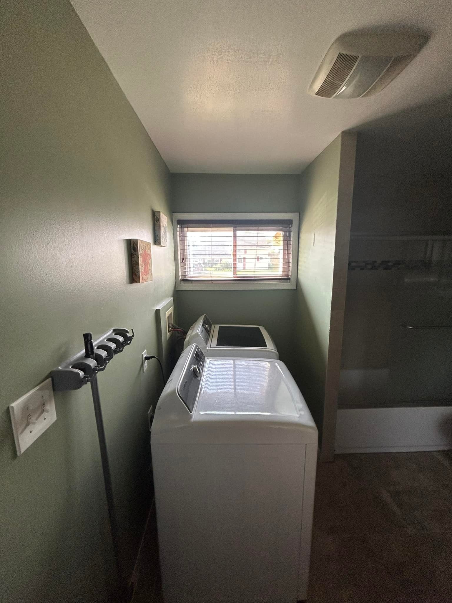 A laundry room with a washer and dryer and a window.
