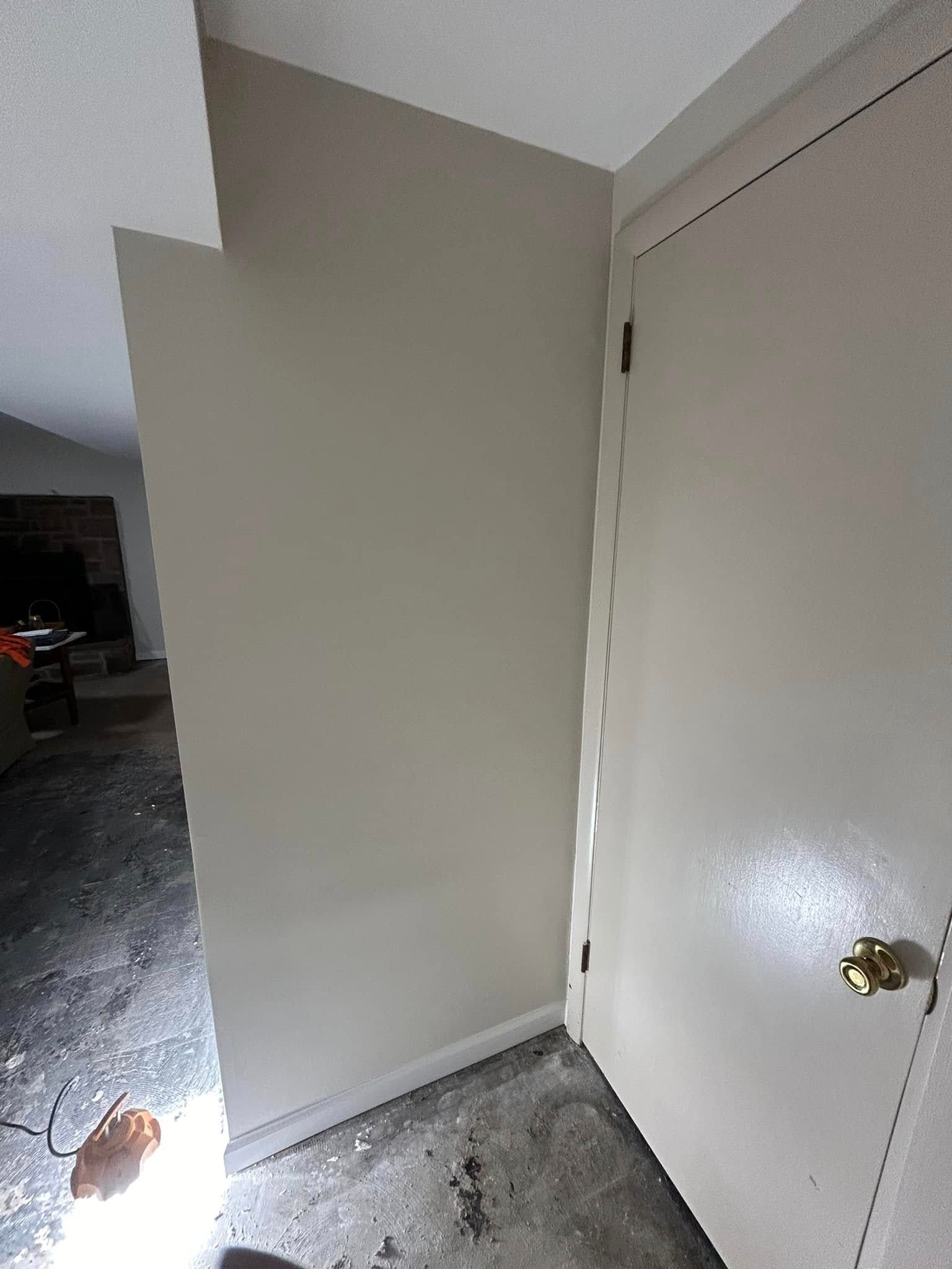 A corner of a room with a door and a wall.