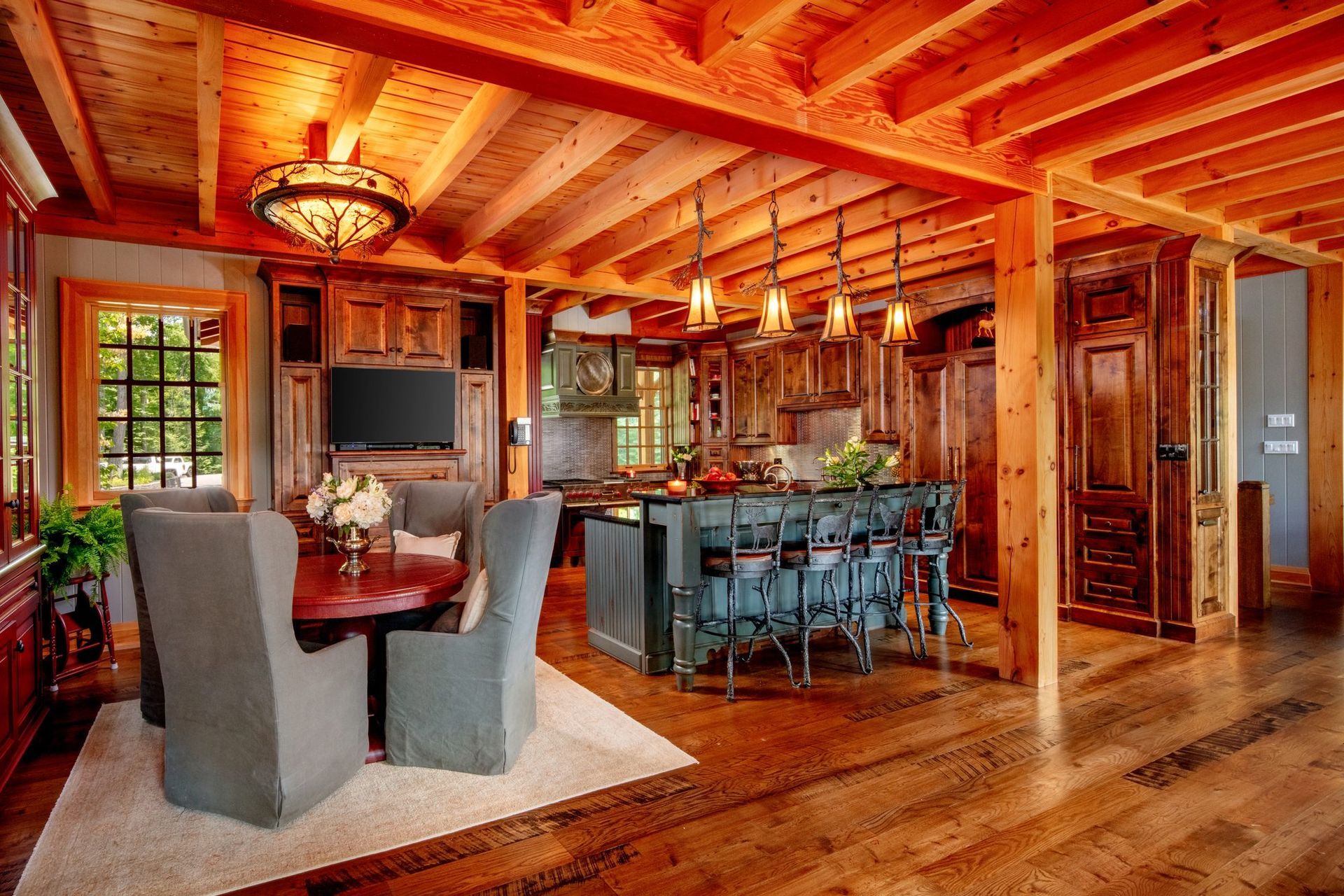 Rustic open-plan living and dining room with exposed wood beams, fireplace, and dining table