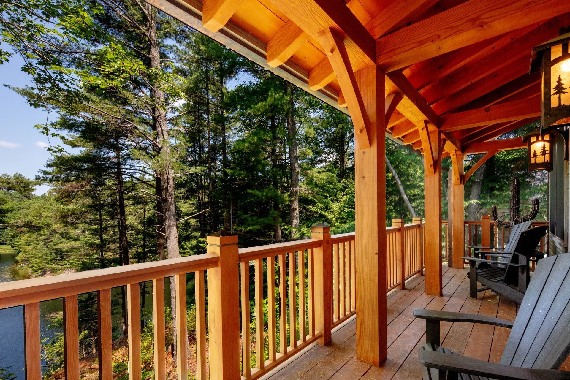 Wooden cabin porch with orange beams overlooking pine trees and mountains