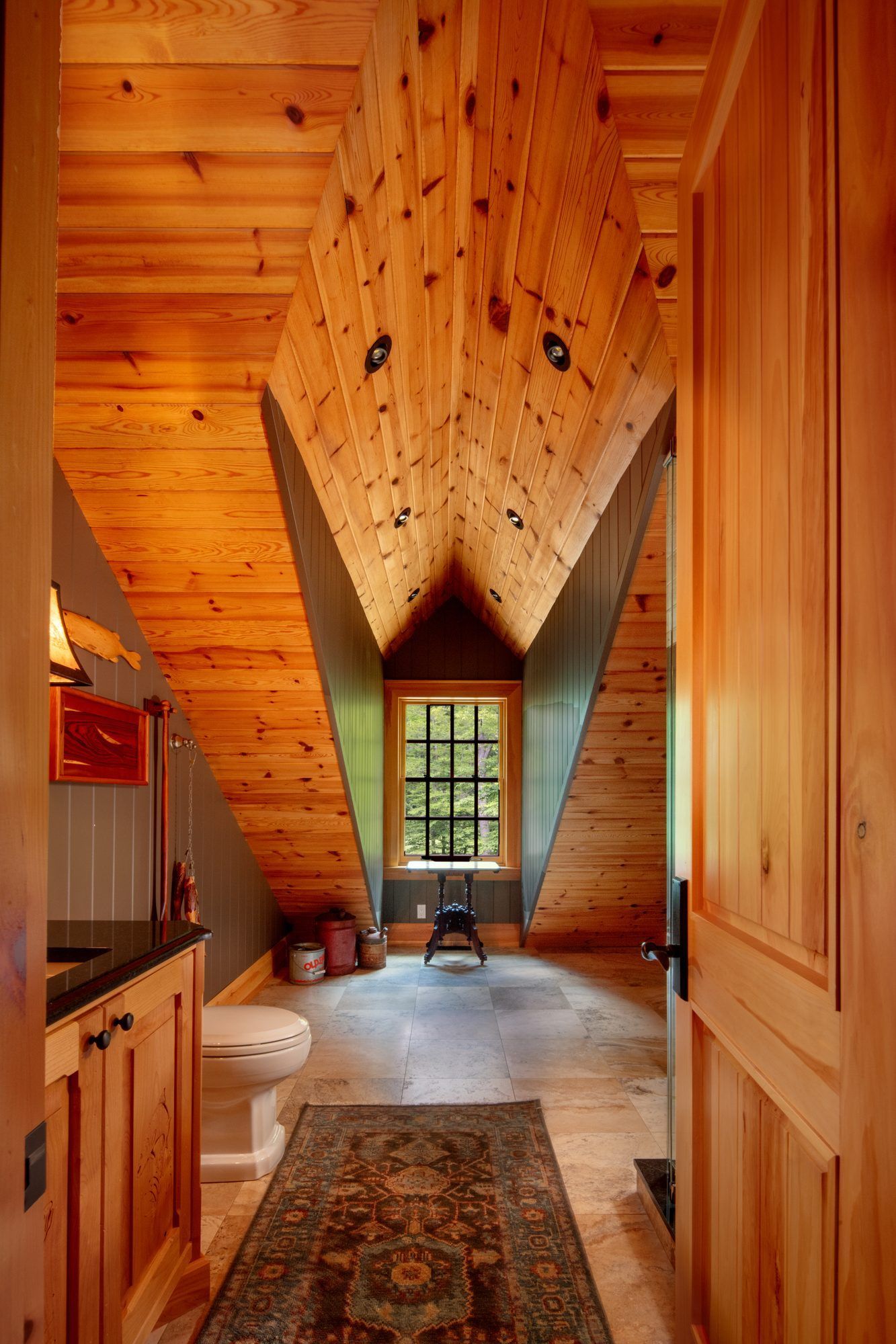 Wood-paneled hallway with a dramatic vaulted ceiling and a window at the far end