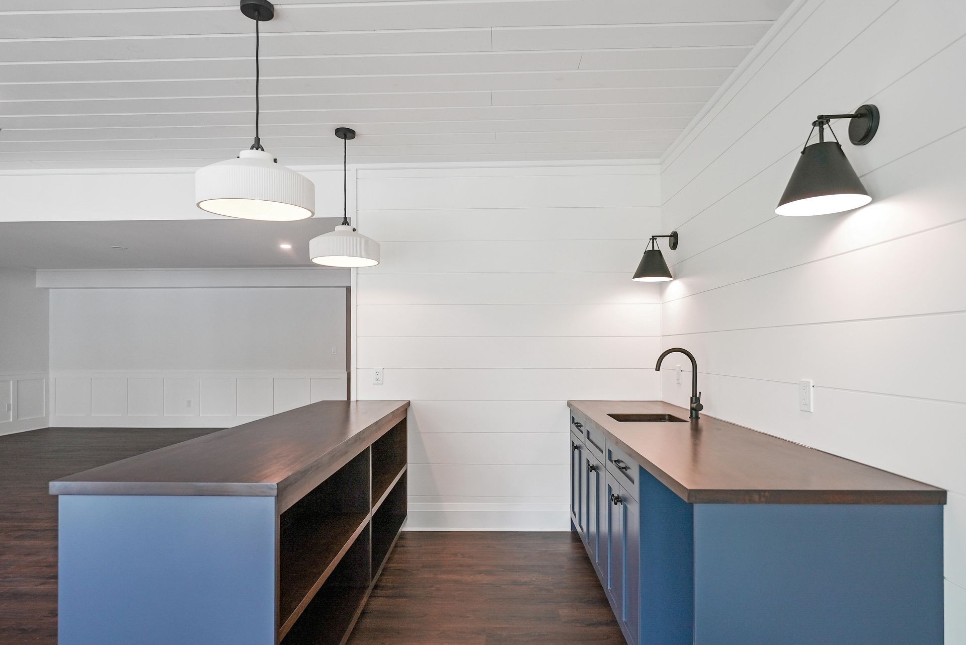 Modern kitchen with blue island cabinets, wood countertops, and pendant lights