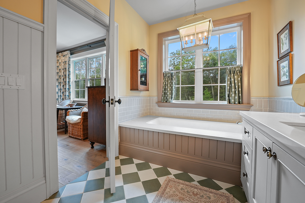 A bathroom with a toilet , sink , mirror and walk in shower.