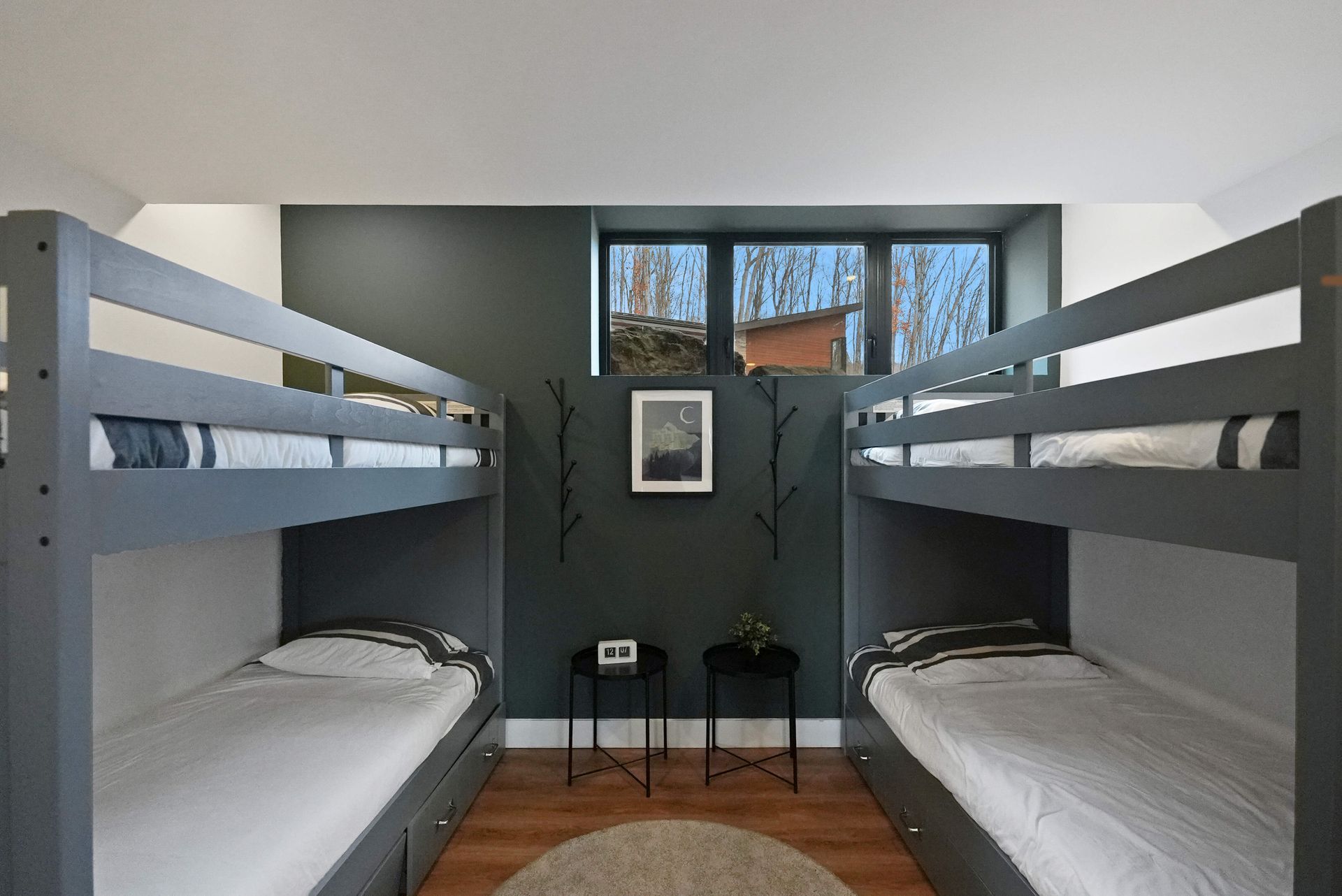 Small bedroom with gray bunk beds on both sides and a window at the back.