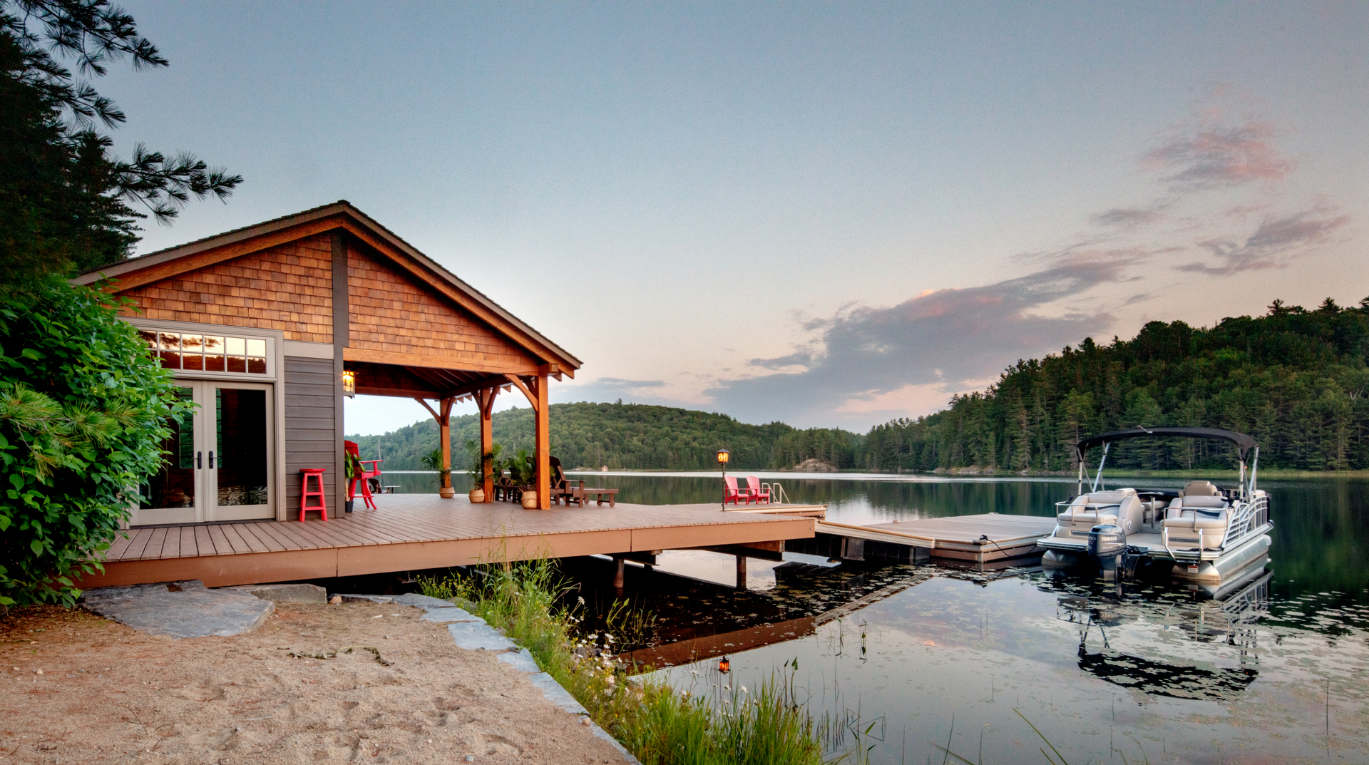 A boat is docked at a dock next to a house on a lake.