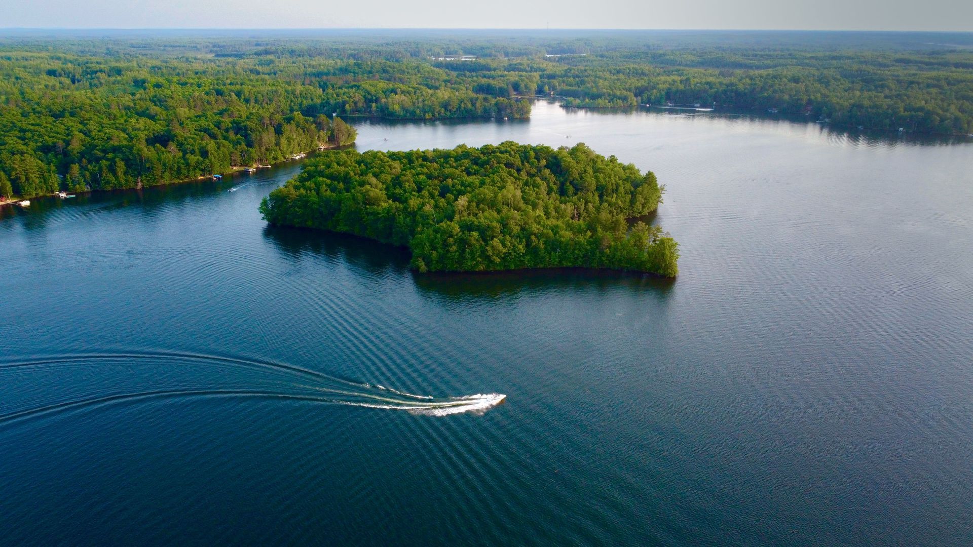 An aerial view of a lake with a small island in the middle.