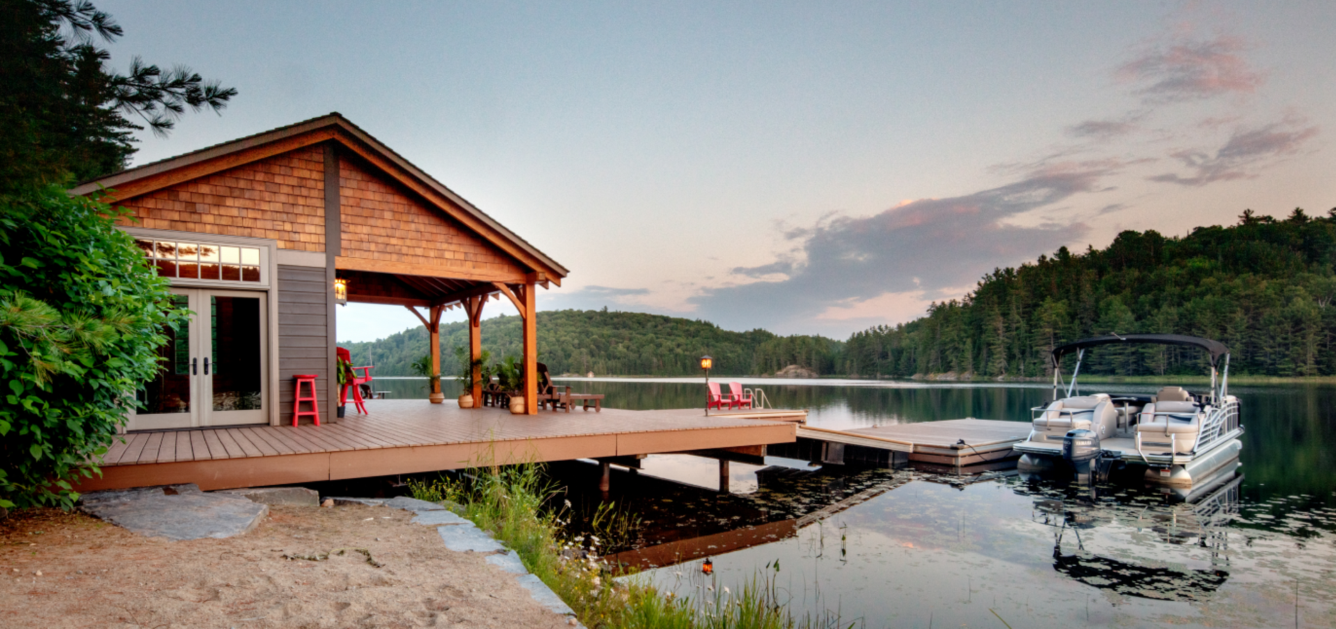 A boat is docked at a dock next to a house on a lake.