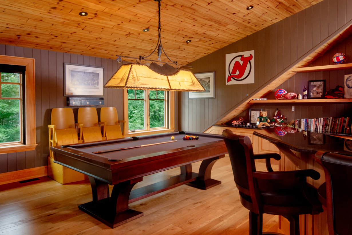 A pool table in a room with a new jersey devils logo on the wall
