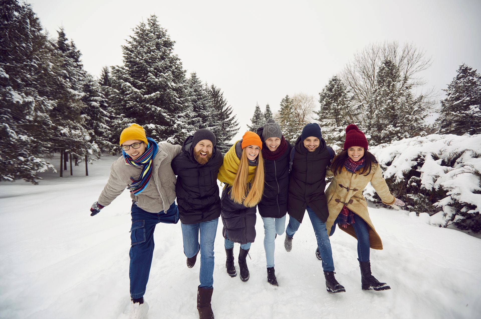 A group of young people are walking through the snow.