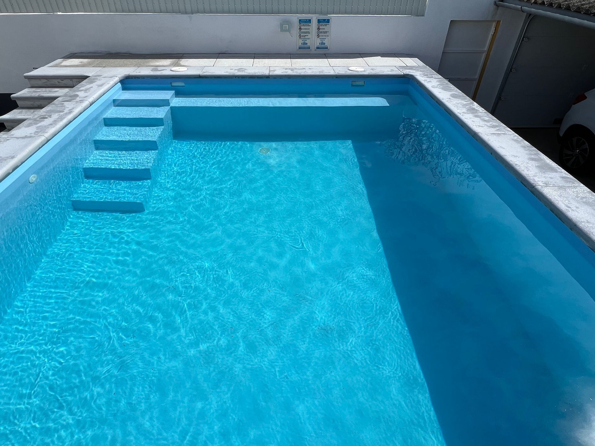 Uma grande piscina com água azul e escadas
