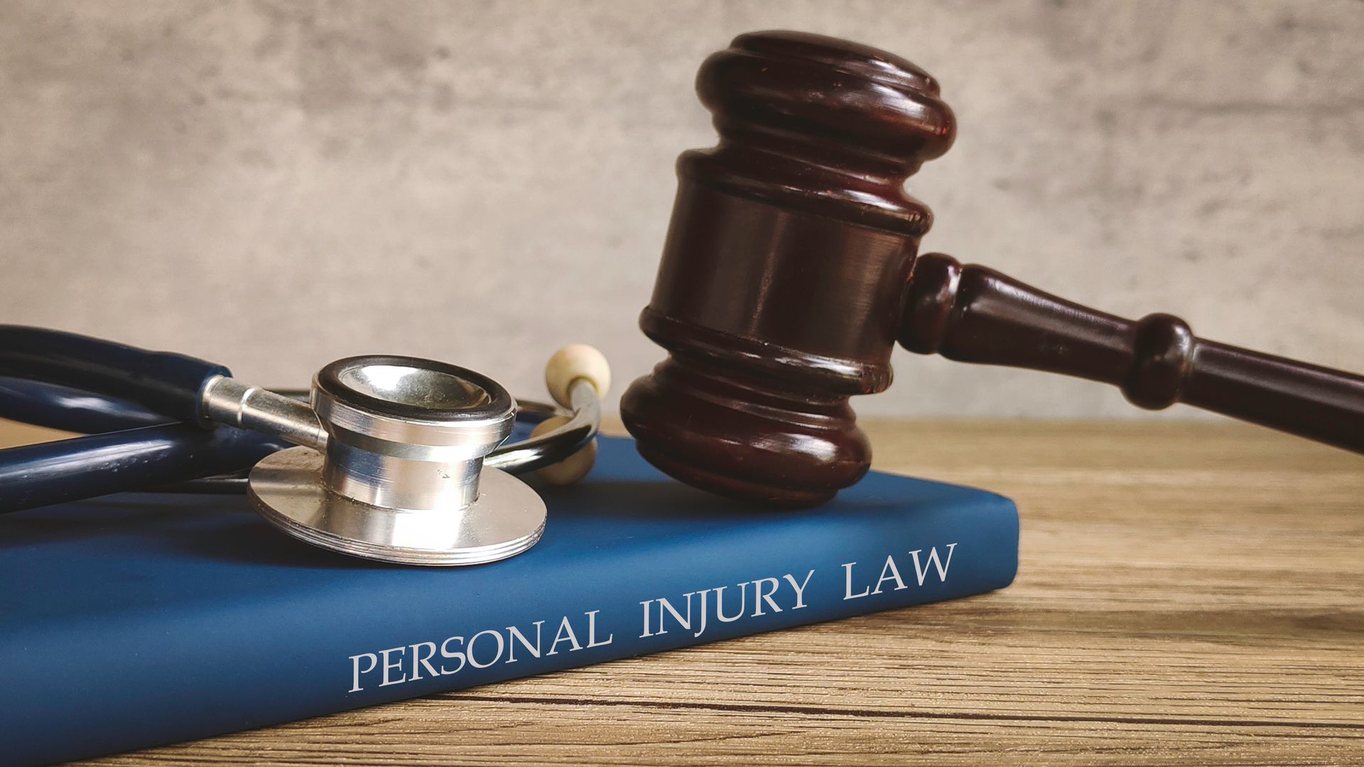 A judge’s gavel and stethoscope resting on a book titled “Personal Injury Law.”