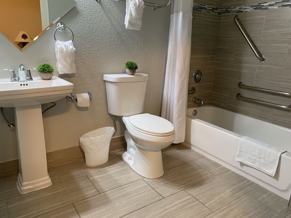 A bathroom with a toilet , sink , and bathtub.