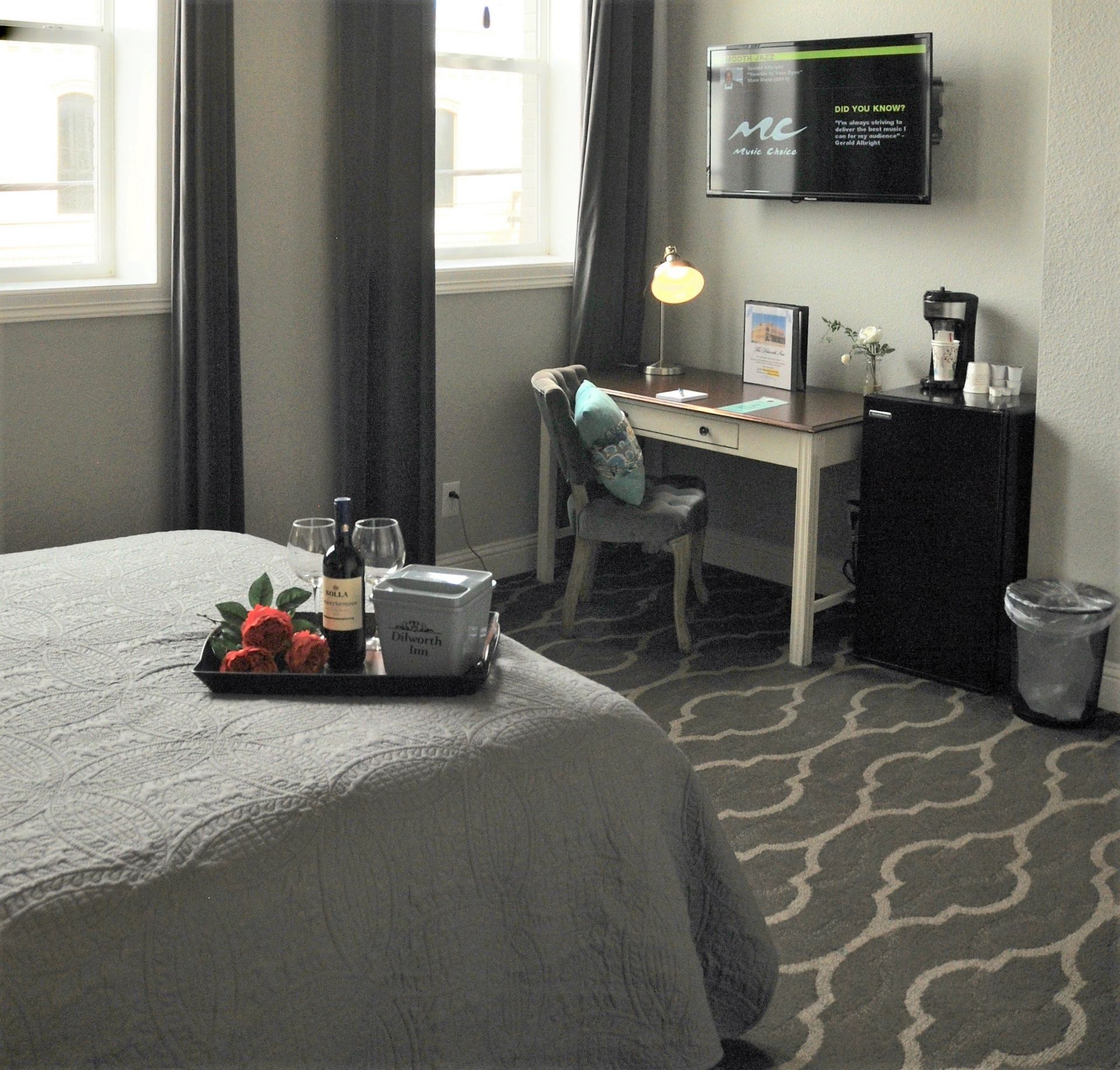 A hotel room with a bed a desk and a flat screen tv