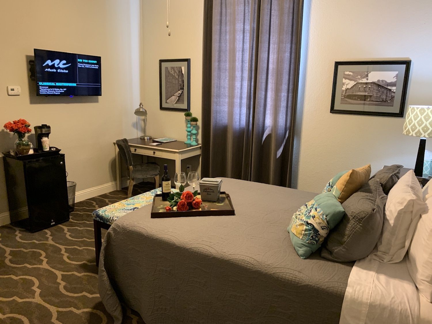 A bedroom with a large bed and a flat screen tv on the wall.