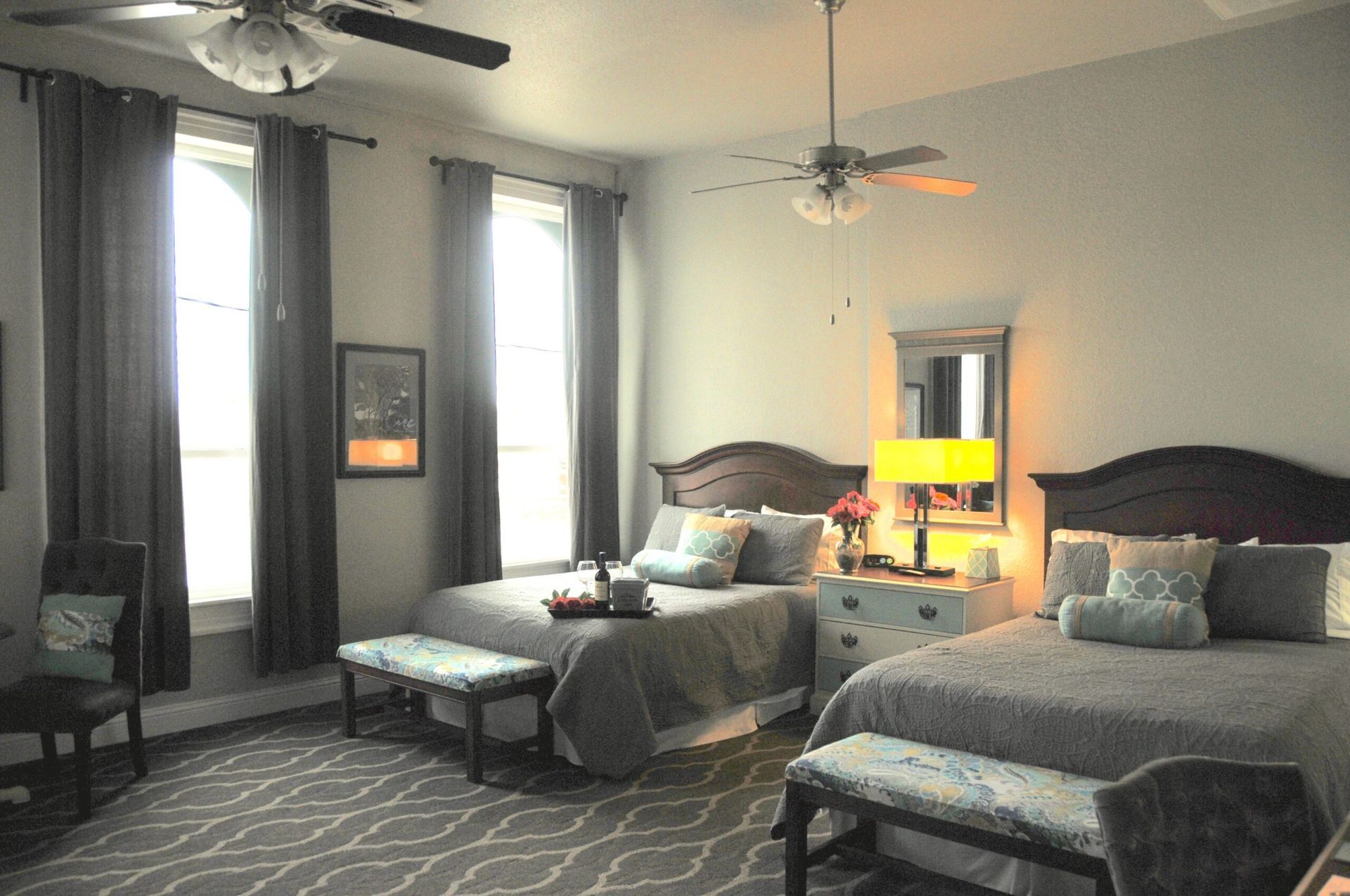 A bedroom with two beds and a ceiling fan