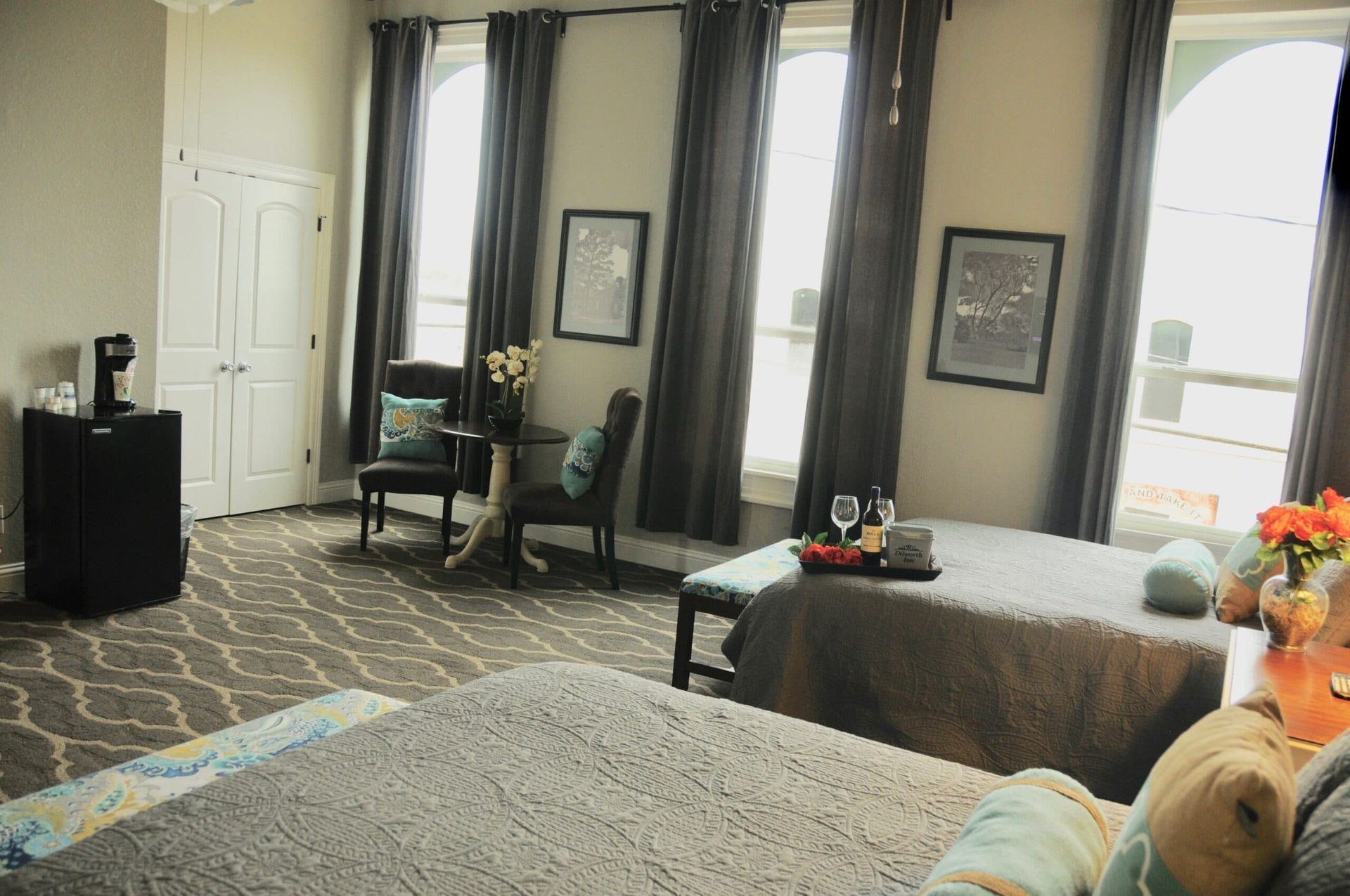 A bedroom with two beds and a chair