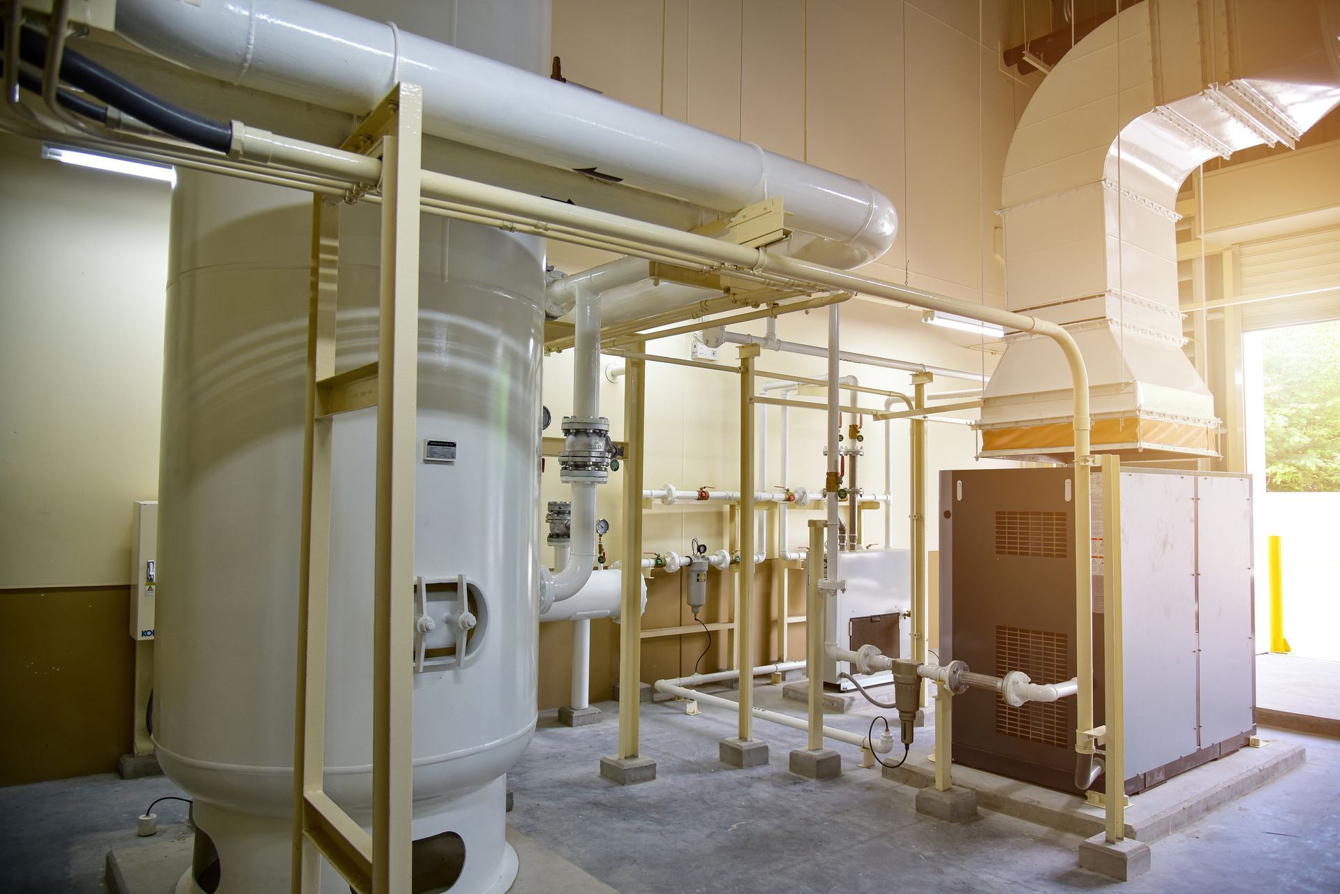 Industrial HVAC system with white and beige pipes and equipment.