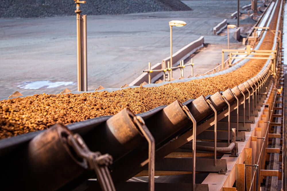 iron ore on conveyor belt — Financial Advisors in Queensland