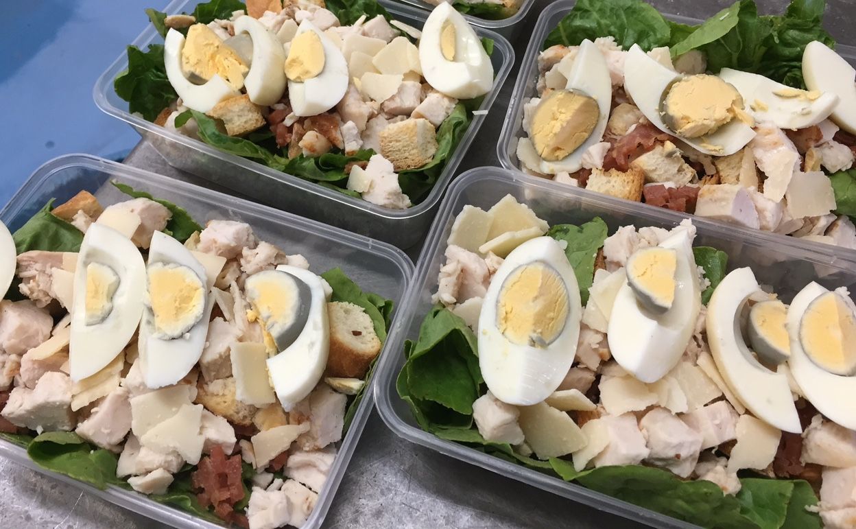 Prepared salads in clear containers: chicken, eggs, croutons, and cheese over green lettuce— Bread Basket in Kurri Kurri, NSW
