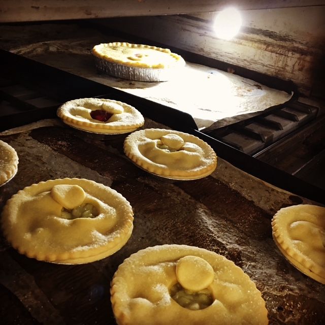 Pies baking in a warm oven with a bright overhead light shining on them— Bread Basket in Kurri Kurri, NSW