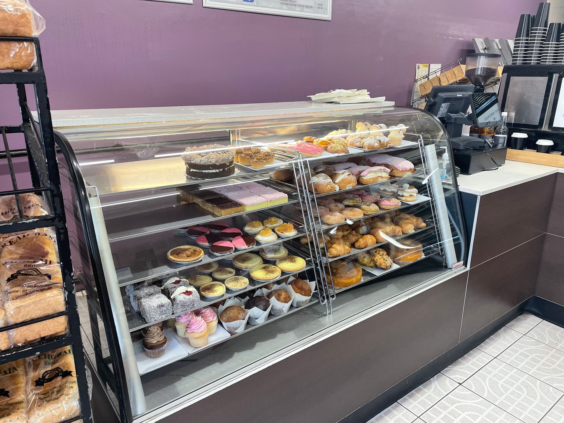 A glass counter in a bakery full of sweet and savoury — Bread Basket in Kurri Kurri, NSW