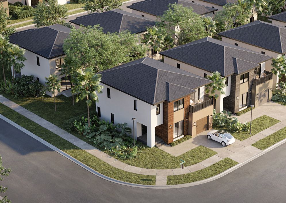 Aerial view of modern suburban townhouses with gray roofs, white walls, and a car parked by the curb.