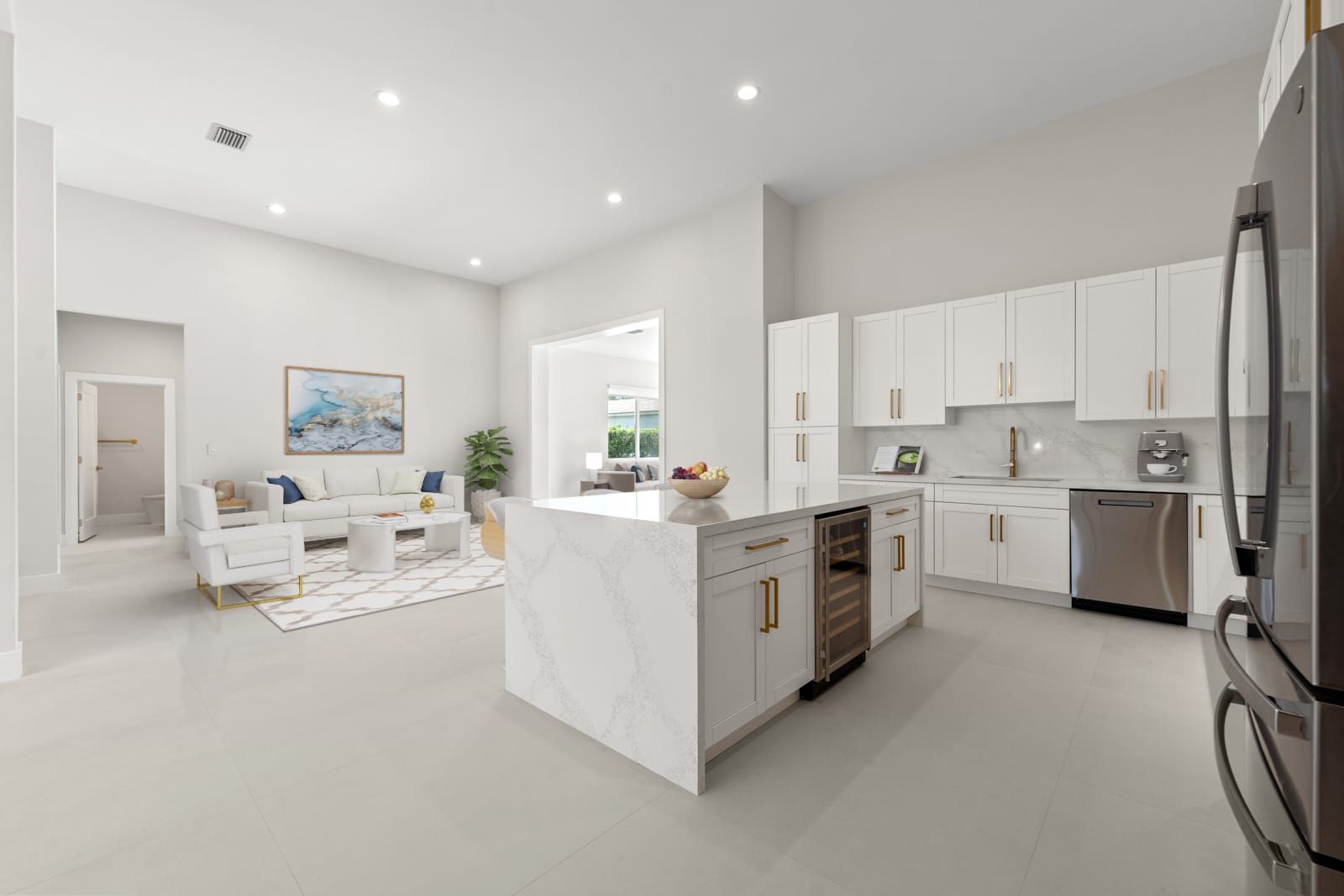 Bright open-plan kitchen and living room with white cabinets, island, gray floors, and recessed lighting