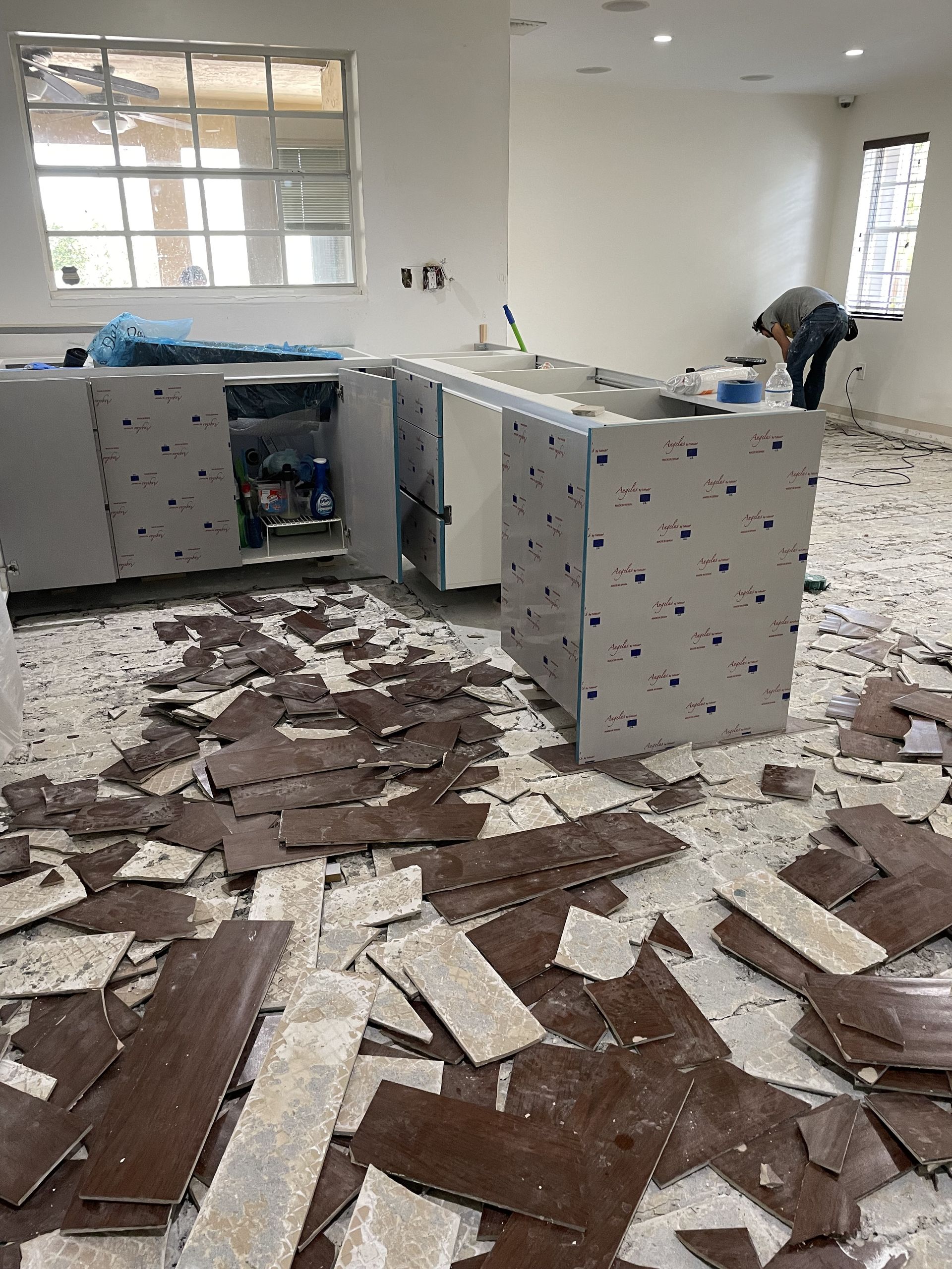 Office interior with debris and broken ceiling tiles scattered across the floor
