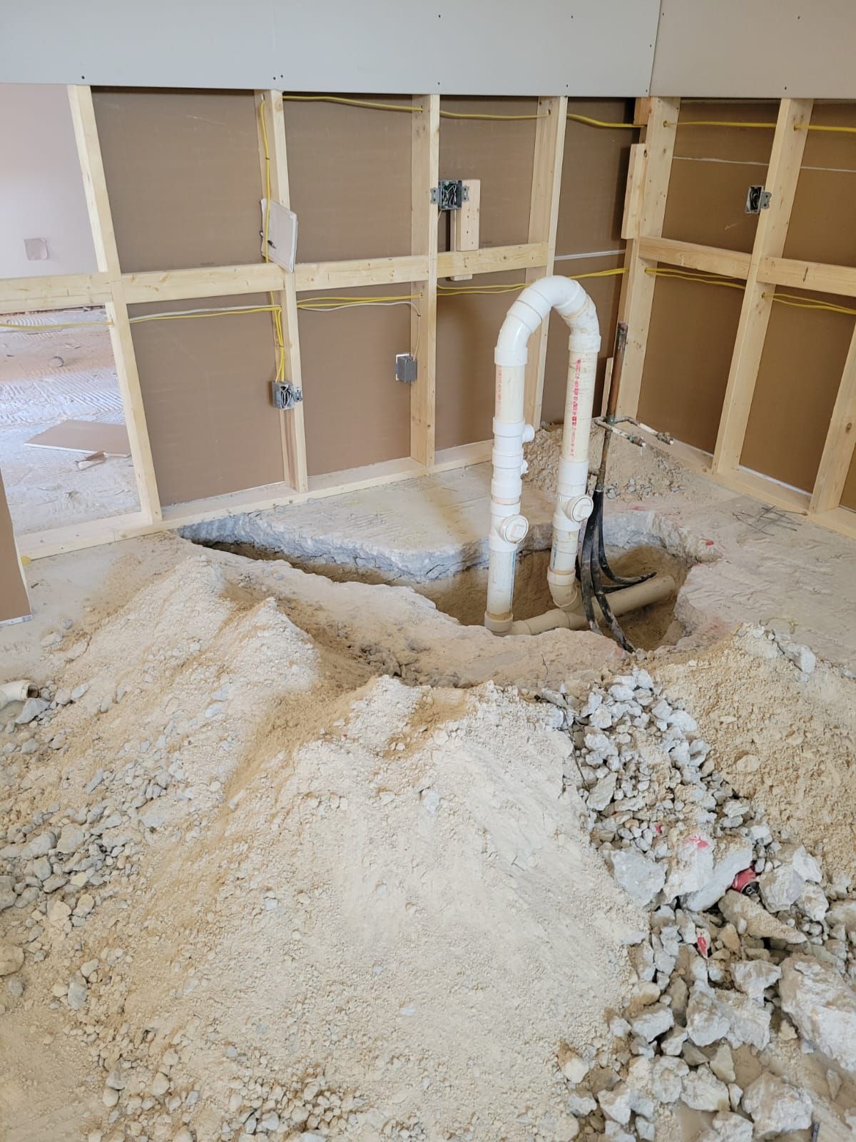 Partially demolished room with exposed wall framing, broken drywall, and debris on the floor