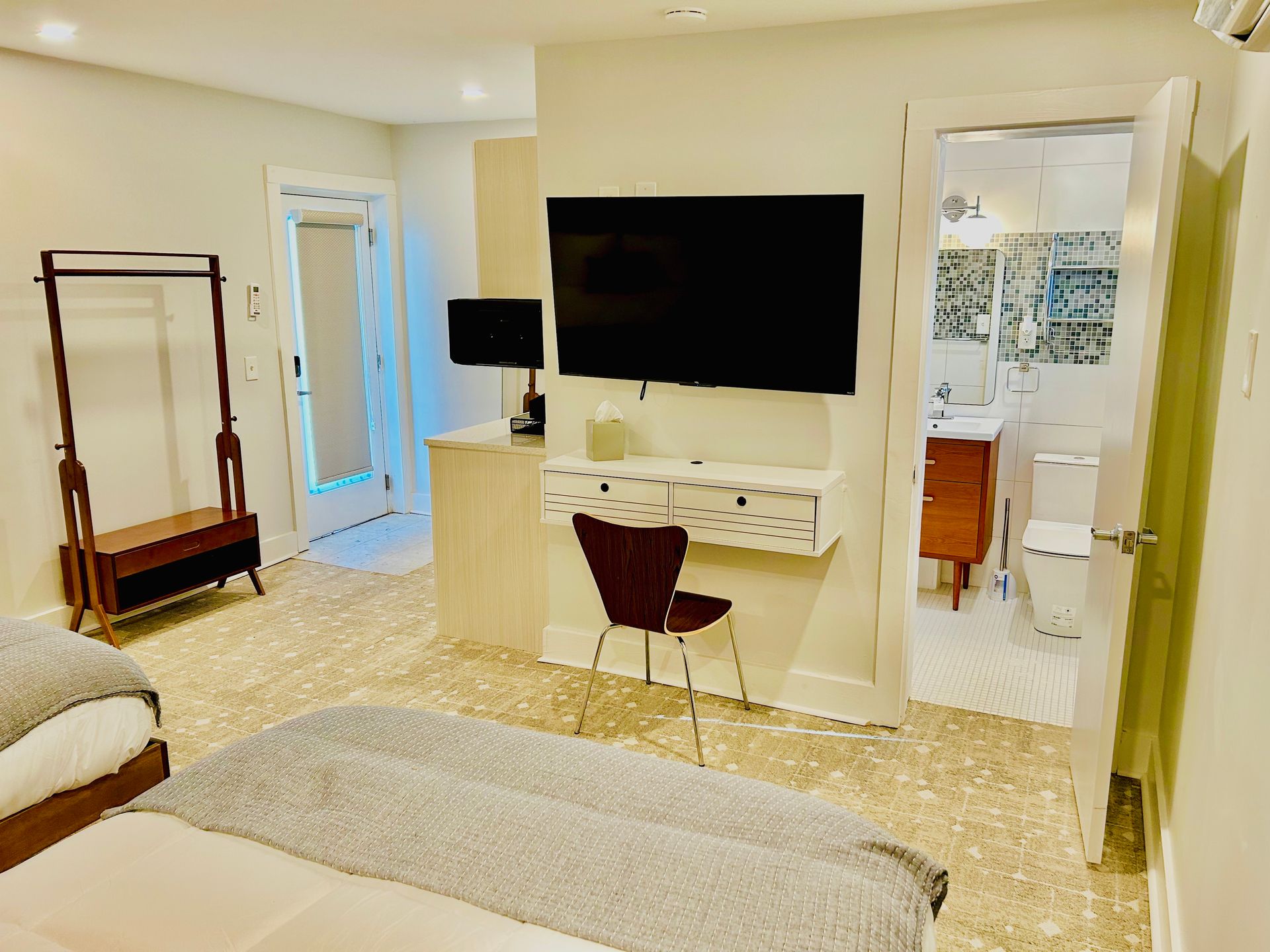 a bedroom with a large flat screen tv on the wall above the bed .