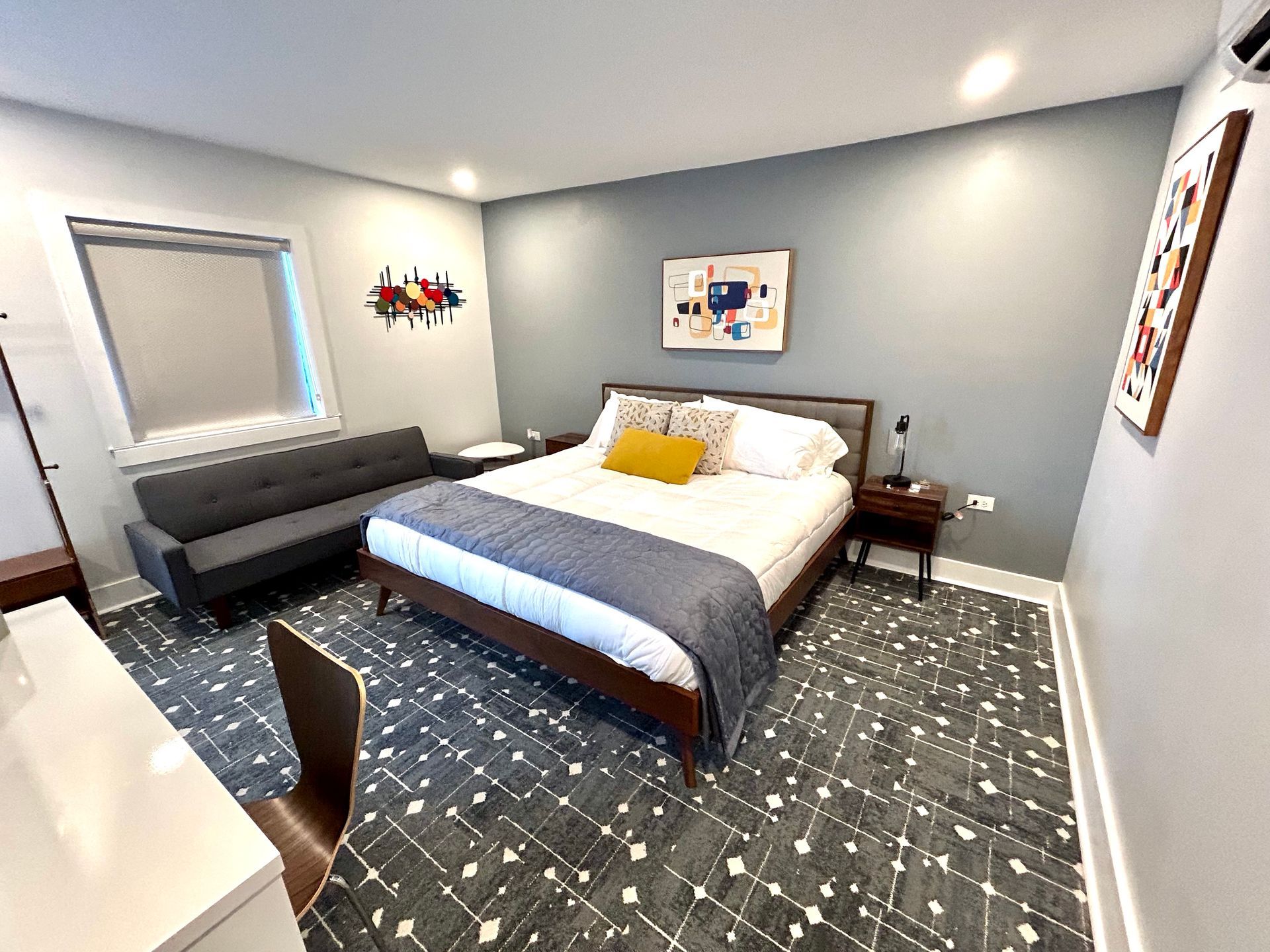 a hotel room with a bed , couch , desk and chairs .
