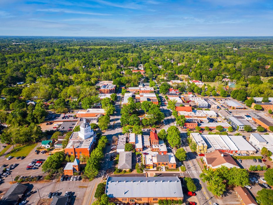 an aerial view of a small town surrounded by trees and buildings .