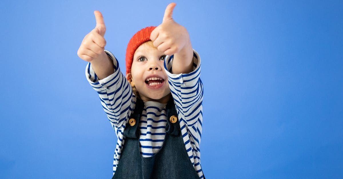 Boy in a red hat giving a thumbs up
