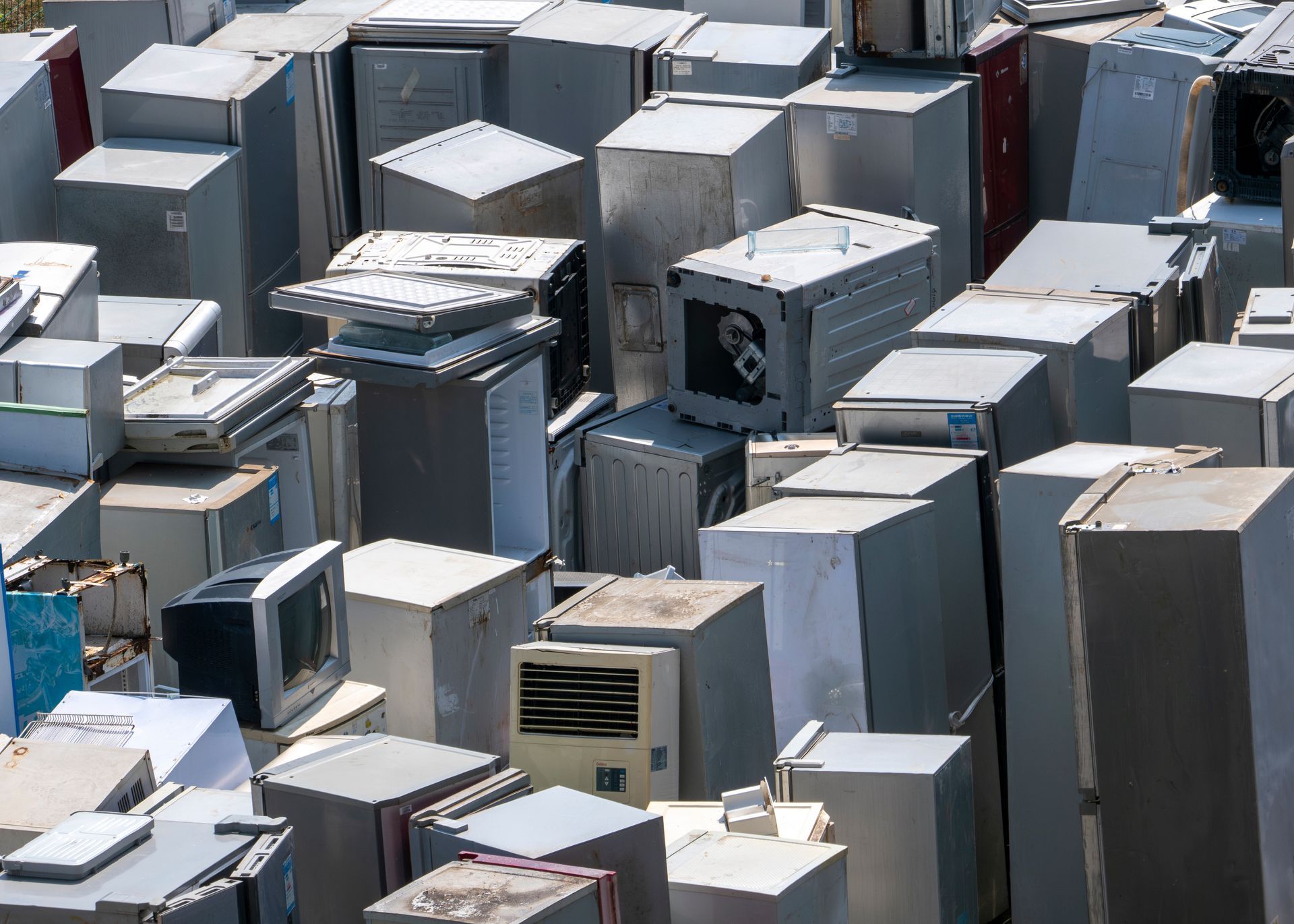 Rows of gray industrial rooftop units packed closely together in a sunny outdoor setting