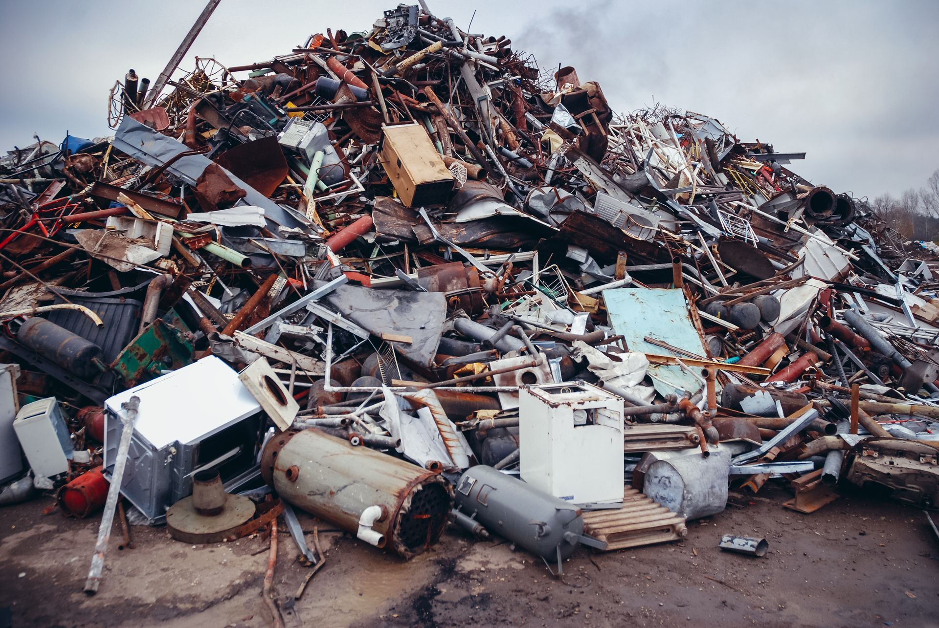 Pile of rusty iron debris at a recycling yard managed by a scrap metal collection dealer.