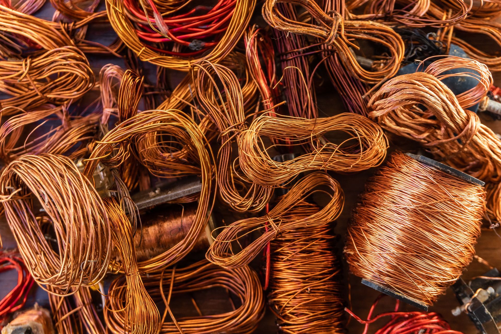 Coiled copper wires and cable scraps piled together in a metal recycling heap