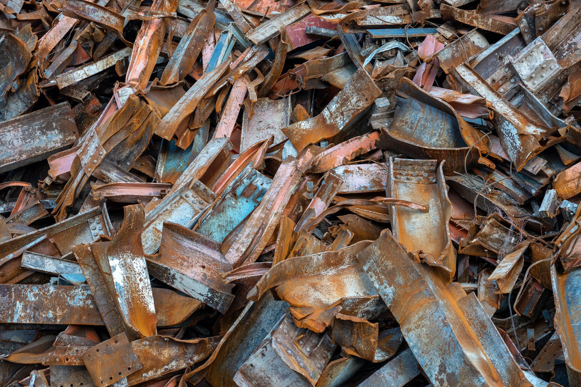 Pile of rusted scrap metal pieces and bent steel fragments stacked together. Pile of rusted scrap metal pieces and bent steel fragments stacked together.