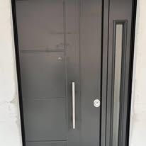 Porta d'ingresso moderna grigia con lunga maniglia argentata e finestra verticale.
