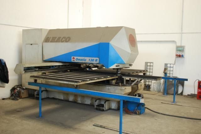 In un'officina industriale ben illuminata, si trova una punzonatrice a torretta CNC MECO Comala 150 B di colore beige e blu.