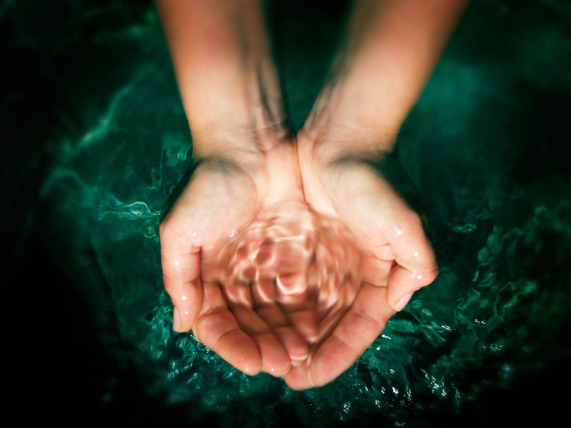 Una persona tiene in mano una goccia d'acqua.