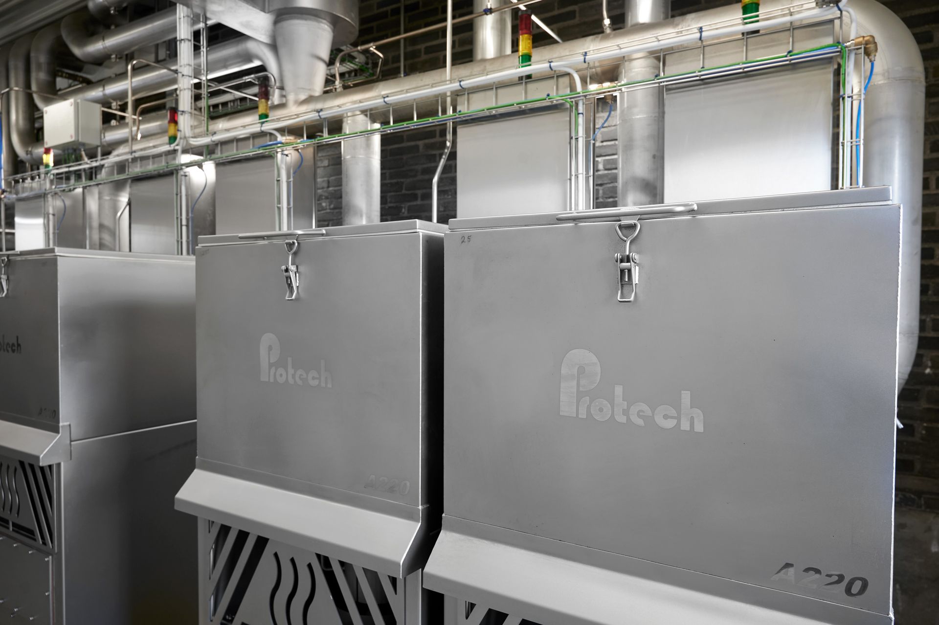 A row of stainless steel boxes are sitting next to each other in a room.