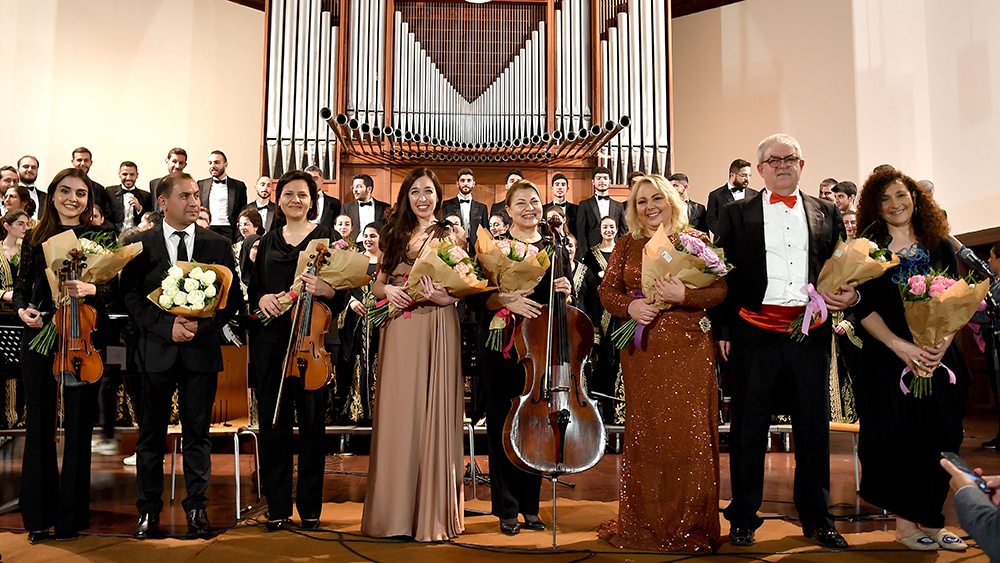 Lynn Zovighian, Maria Mattar & Barkev Taslakian in the foreground holding flowers at the Giving Voice to Music concert.