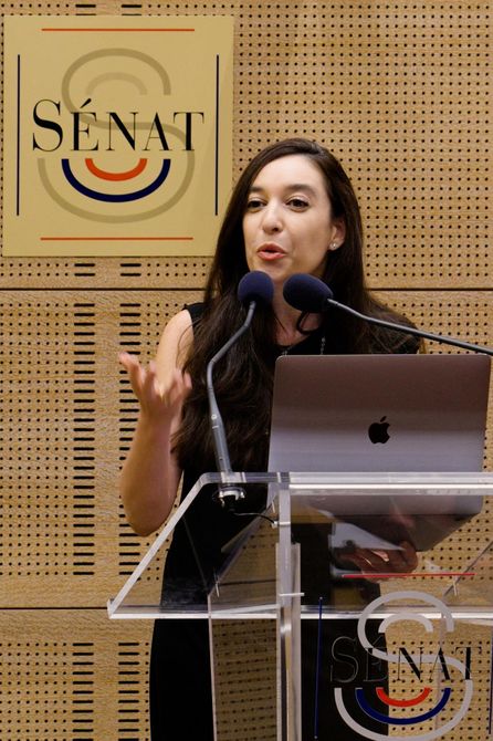 Lynn Zovighian speaking at a podium at the Palace of Luxembourg during a Yazidi Genocide conference.