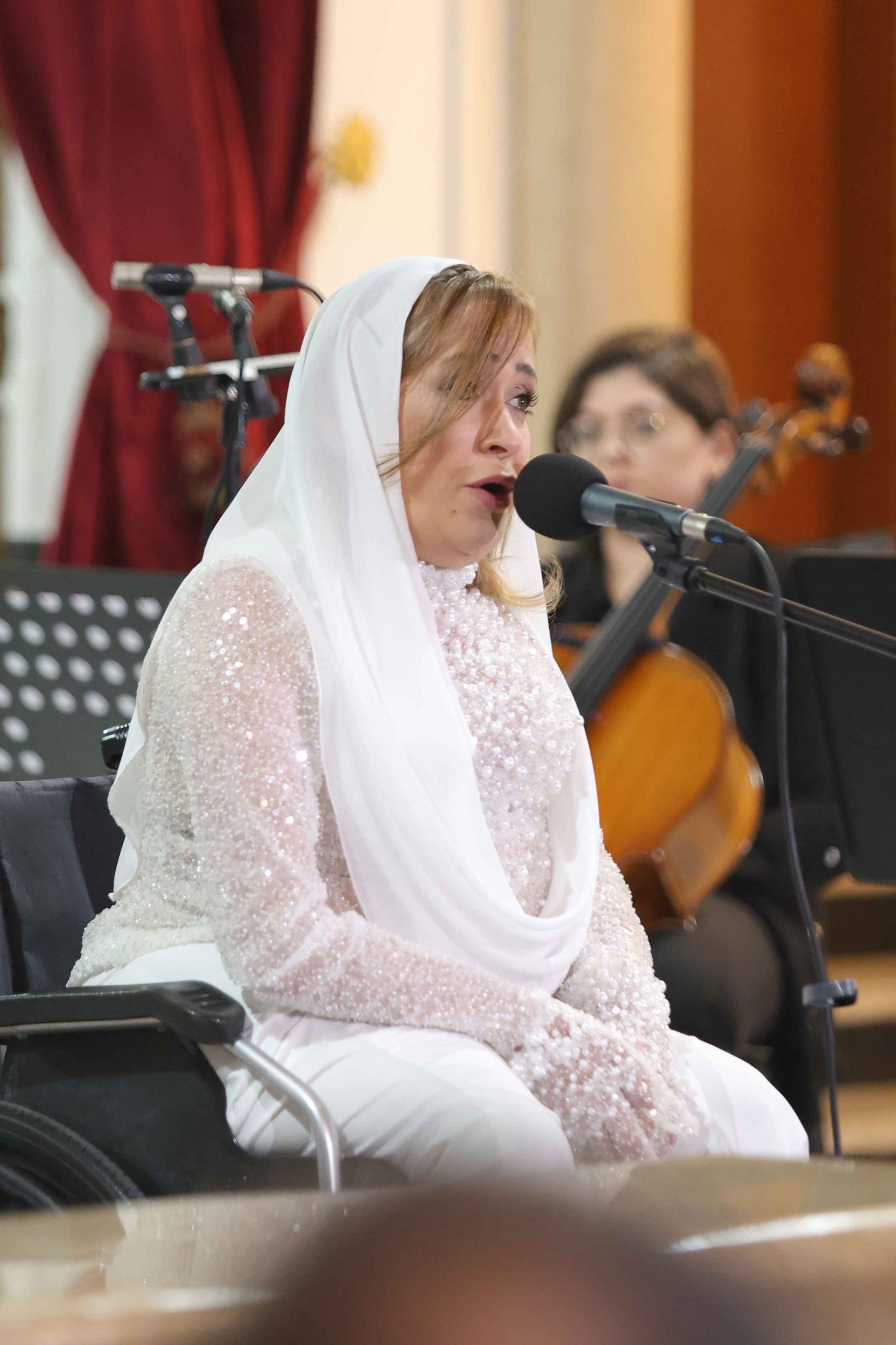 Pauline at the Giving Voice to Hope concert at AUB Hall, with the Al Fayha National choir seated and singing.