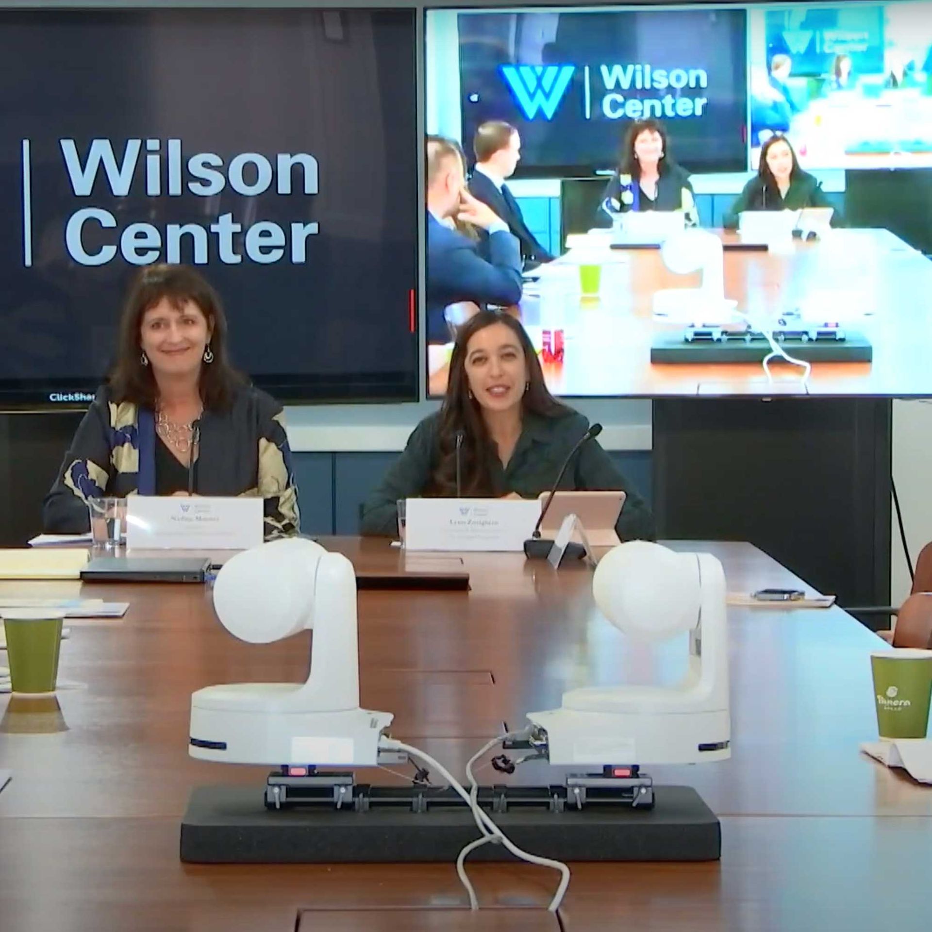 Panel discussion at the Wilson Center with Lynn Zovighian & Nadine Maezna in foreground, screens with Wilson Center logo.